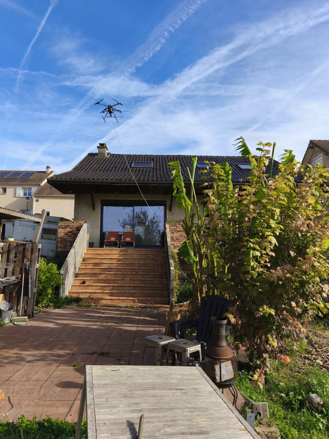 Drone RenoDrone en vol au-dessus d'une toiture pour un démoussage sans échafaudage
